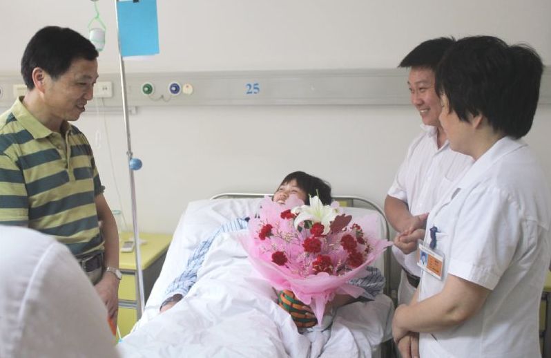 东吴中西医结合医院曾志贤院长(左一)与手术主刀医生谭晓静主任(右一)到病房看望手术后的花女士